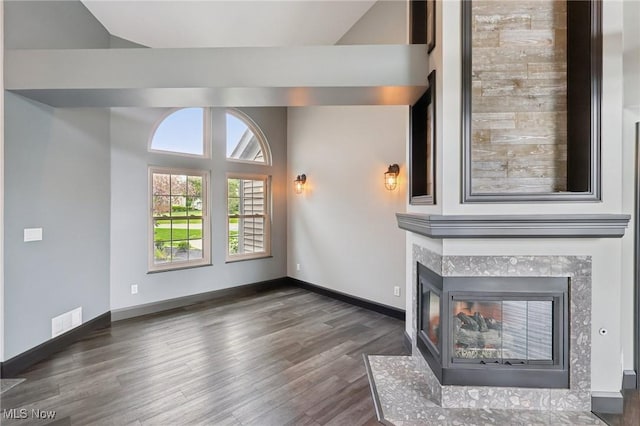 322 N Bayshore Dr Unit 3, Columbiana, OH 44408 - unfurnished living room featuring wood finished floors, lofted ceiling, a multi sided fireplace, and baseboards