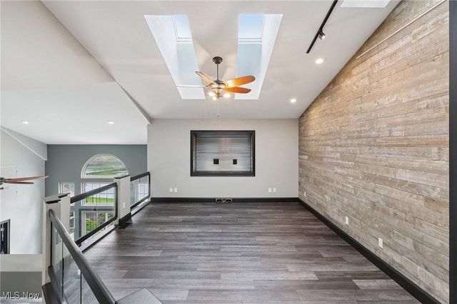 322 N Bayshore Dr Unit 3, Columbiana, OH 44408 - spare room with an accent wall, a skylight, wood walls, vaulted ceiling, and a ceiling fan