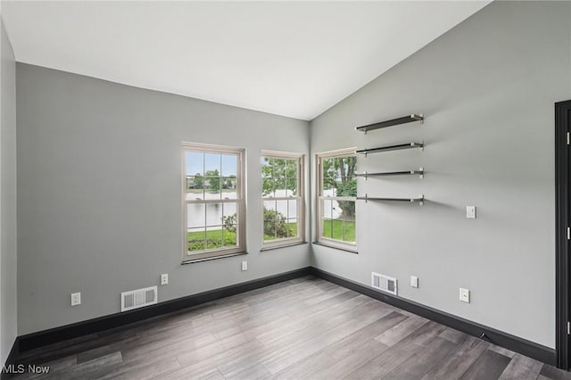 322 N Bayshore Dr Unit 3, Columbiana, OH 44408 - spare room featuring wood finished floors, lofted ceiling, a water view, and baseboards