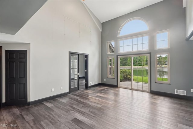 322 N Bayshore Dr Unit 3, Columbiana, OH 44408 - unfurnished living room featuring a high ceiling, dark wood finished floors, and baseboards