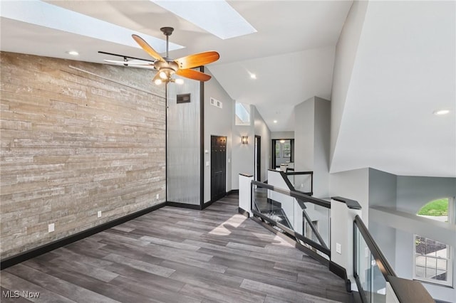 322 N Bayshore Dr Unit 3, Columbiana, OH 44408 - hallway featuring an upstairs landing, an accent wall, a skylight, wooden walls, and wood finished floors