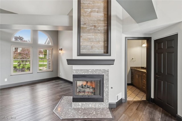 322 N Bayshore Dr Unit 3, Columbiana, OH 44408 - unfurnished living room featuring dark wood-style flooring, a tile fireplace, and baseboards