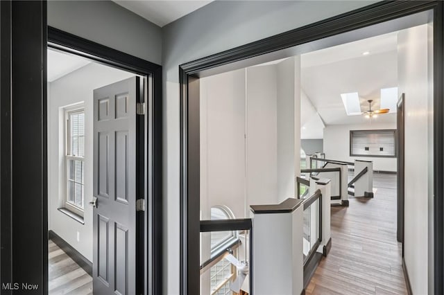 322 N Bayshore Dr Unit 3, Columbiana, OH 44408 - hall featuring a skylight, an upstairs landing, light wood-style floors, and baseboards