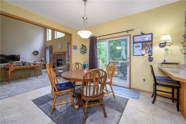 536 Silver Creek Dr, Doylestown, OH 44230 - dining space with a fireplace, light tile patterned floors, and baseboards