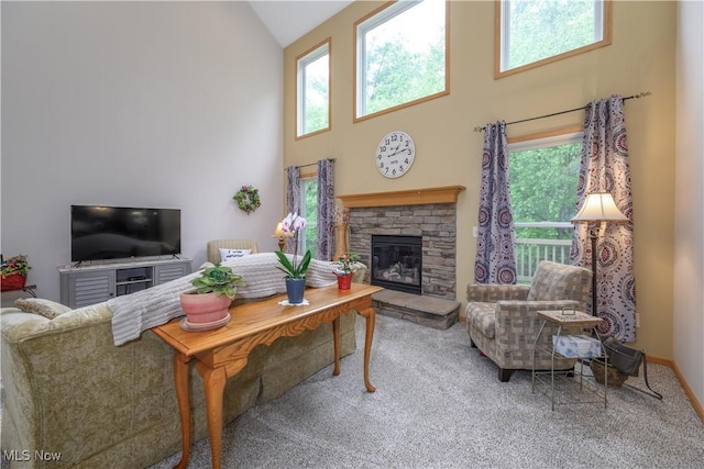 536 Silver Creek Dr, Doylestown, OH 44230 - carpeted living area featuring high vaulted ceiling, a stone fireplace, and plenty of natural light