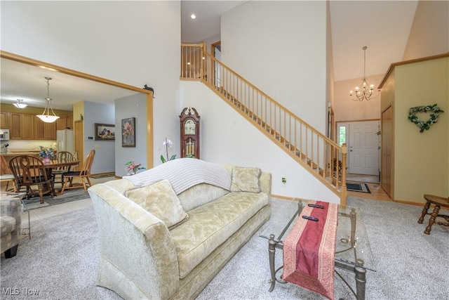 536 Silver Creek Dr, Doylestown, OH 44230 - living room featuring a towering ceiling, stairs, a chandelier, light colored carpet, and baseboards