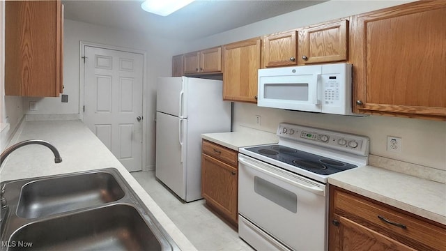 28360 Center Ridge Rd Unit 218, Westlake, OH 44145 - kitchen with white appliances, a sink, light countertops, and brown cabinetry