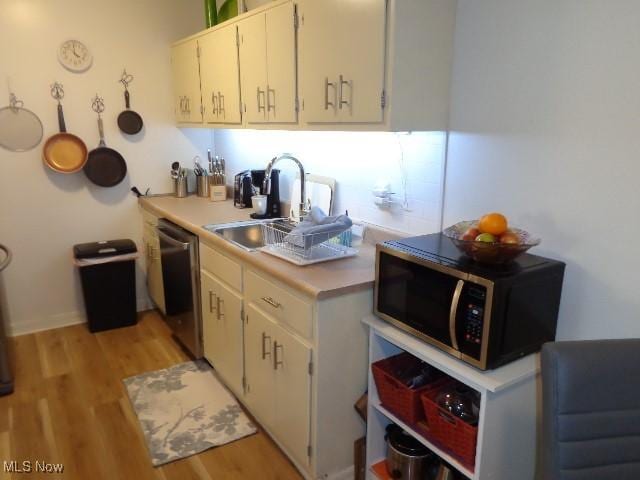 16395 Heather Ln Unit 201, Middleburg Heights, OH 44130 - kitchen with appliances with stainless steel finishes, light wood-style floors, light countertops, a sink, and white cabinets