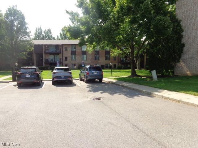16395 Heather Ln Unit 201, Middleburg Heights, OH 44130 - view of front of house with uncovered parking, a front lawn, and brick siding