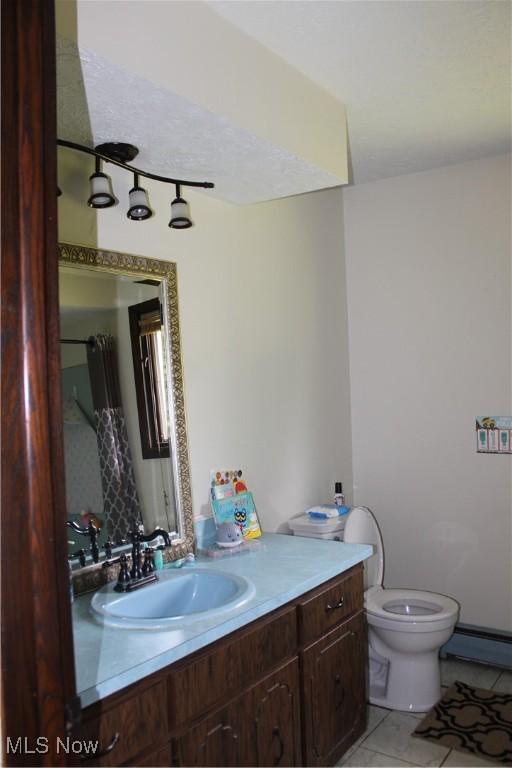 666 E Windsor Rd, Orwell, OH 44076 - bathroom with vanity, toilet, tile patterned floors, and a baseboard radiator