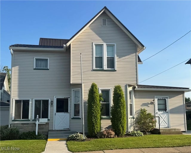 99 W Martin St, East Palestine, OH 44413 - view of front of house featuring entry steps, a front lawn, and metal roof
