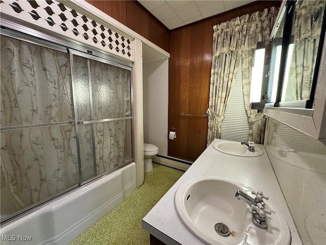 99 W Martin St, East Palestine, OH 44413 - full bath featuring a baseboard heating unit, toilet, double vanity, wood walls, and combined bath / shower with glass door