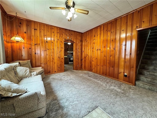99 W Martin St, East Palestine, OH 44413 - carpeted living area with a ceiling fan, wood walls, and stairway