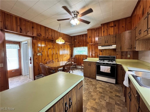 99 W Martin St, East Palestine, OH 44413 - kitchen with gas range, wooden walls, under cabinet range hood, ceiling fan, and light countertops