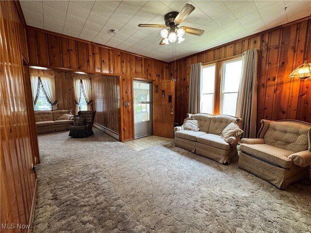 99 W Martin St, East Palestine, OH 44413 - living room featuring wood walls, a ceiling fan, carpet floors, and baseboard heating