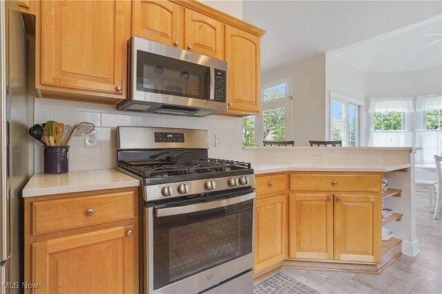 1983 Fox Trace Trl, Cuyahoga Falls, OH 44223 - kitchen featuring stainless steel appliances, light countertops, a peninsula, and backsplash