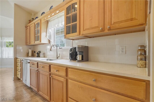1983 Fox Trace Trl, Cuyahoga Falls, OH 44223 - kitchen featuring a sink, stainless steel dishwasher, light countertops, tasteful backsplash, and glass insert cabinets