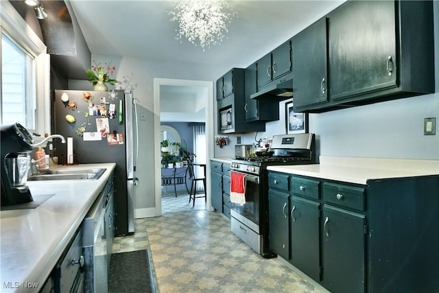 3053 E Market St, Warren, OH 44483 - kitchen with appliances with stainless steel finishes, under cabinet range hood, a sink, light countertops, and light floors