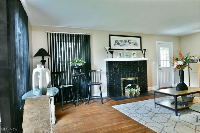 3053 E Market St, Warren, OH 44483 - living room with wood finished floors, a brick fireplace, and baseboards