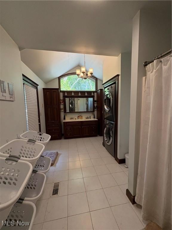 803 N 7th St, Cambridge, OH 43725 - bathroom featuring stacked washer / drying machine, vaulted ceiling, a chandelier, tile patterned floors, and vanity