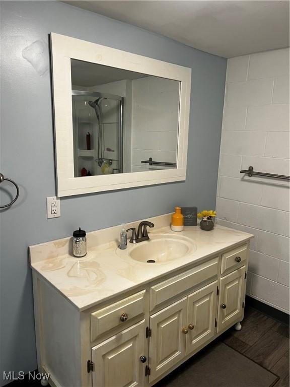 803 N 7th St, Cambridge, OH 43725 - bathroom featuring vanity, a shower with door, and wood finished floors