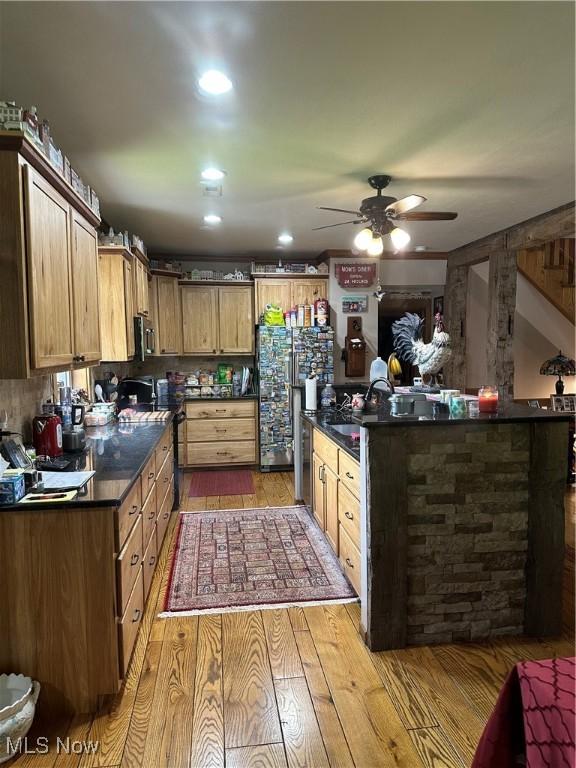 51001 Run Rd, Beallsville, OH 43716 - kitchen with light wood-style floors, freestanding refrigerator, a ceiling fan, dark countertops, and stainless steel microwave