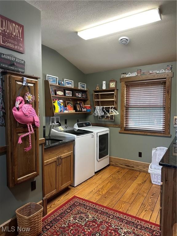 51001 Run Rd, Beallsville, OH 43716 - washroom with cabinet space, washing machine and clothes dryer, light wood-style flooring, baseboards, and a textured ceiling