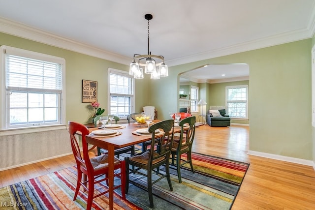 2500 Eaton Rd, University Heights, OH 44118 - dining room with arched walkways, light wood-type flooring, crown molding, a chandelier, and baseboards