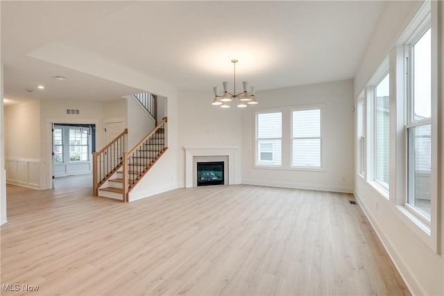 S/L12 Neptune Oval, Solon, OH 44139 - unfurnished living room with light wood finished floors, a chandelier, stairs, baseboards, and recessed lighting