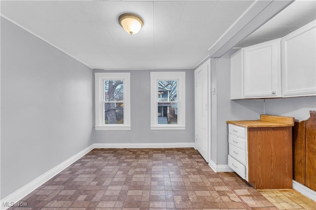 4611 W 41st St, Cleveland, OH 44109 - unfurnished dining area with brick patterned flooring and baseboards