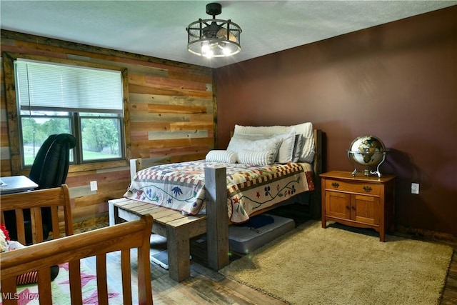 6416 Wilson Sharpsville Rd, Fowler, OH 44418 - bedroom with light wood-type flooring, wooden walls, and a chandelier