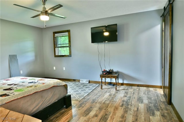 6416 Wilson Sharpsville Rd, Fowler, OH 44418 - bedroom featuring wood finished floors, baseboards, and a barn door