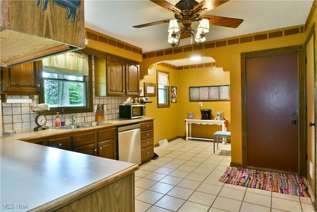 6416 Wilson Sharpsville Rd, Fowler, OH 44418 - kitchen with stainless steel appliances, a sink, ceiling fan, decorative backsplash, and light countertops