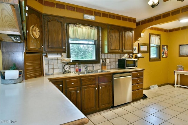 6416 Wilson Sharpsville Rd, Fowler, OH 44418 - kitchen featuring appliances with stainless steel finishes, a sink, light countertops, decorative backsplash, and light tile patterned floors