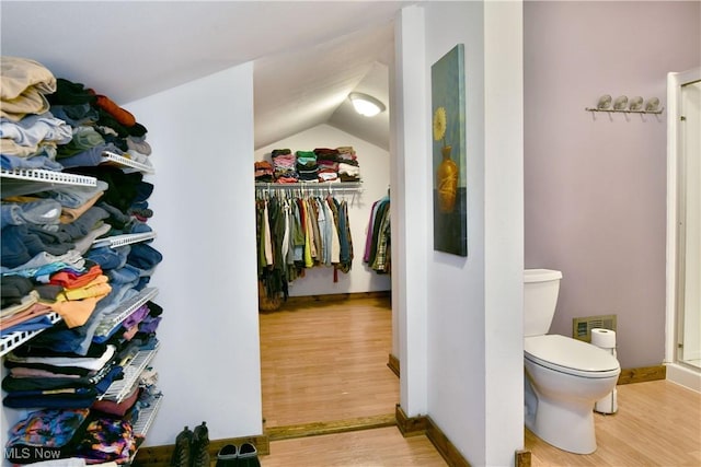 6416 Wilson Sharpsville Rd, Fowler, OH 44418 - bathroom featuring wood finished floors, toilet, a walk in closet, vaulted ceiling, and baseboards
