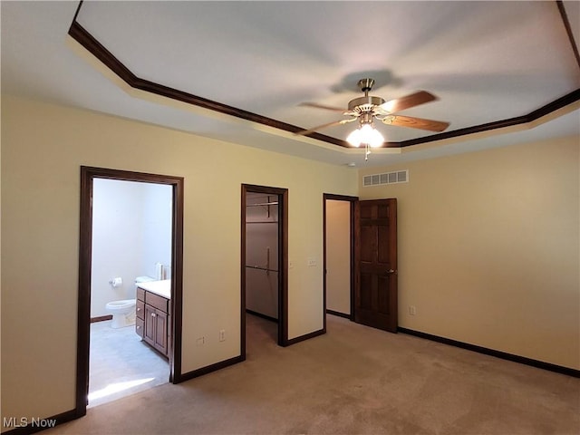 3172 Kinata Ct, West Salem, OH 44287 - unfurnished bedroom featuring a tray ceiling, light colored carpet, crown molding, ensuite bathroom, and baseboards