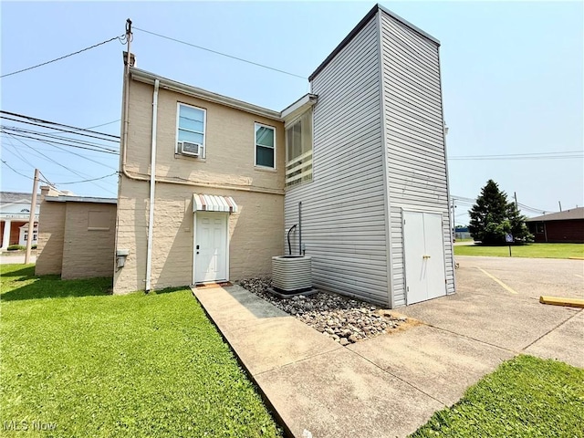 2007 Washington Blvd, Belpre, OH 45714 - back of house featuring a lawn, central AC unit, cooling unit, and stucco siding