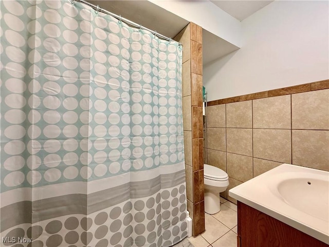 2007 Washington Blvd, Belpre, OH 45714 - full bathroom featuring tile walls, vanity, toilet, tile patterned floors, and a wainscoted wall