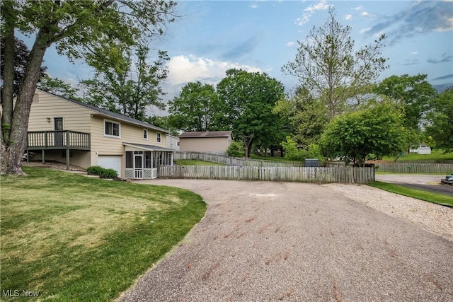 715 Locust St S, Canal Fulton, OH 44614 - view of yard with driveway, a garage, and a sunroom