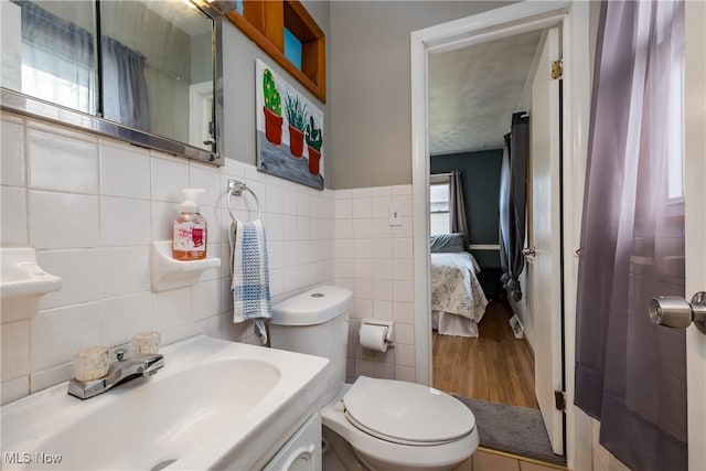 715 Locust St S, Canal Fulton, OH 44614 - bathroom with tile walls, toilet, vanity, ensuite bathroom, and wood finished floors