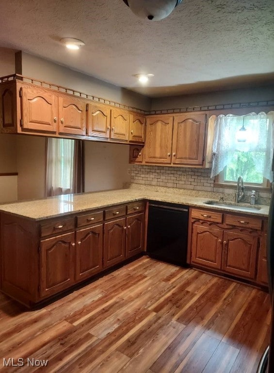 130 Maze Rd, Belpre, OH 45714 - kitchen featuring dishwasher, a textured ceiling, light wood-style floors, decorative backsplash, and a peninsula