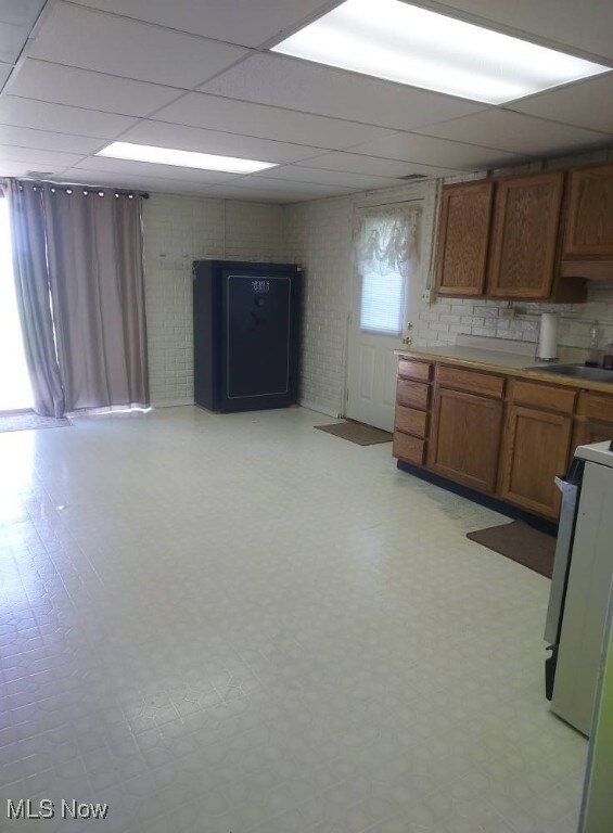 130 Maze Rd, Belpre, OH 45714 - kitchen with range, brown cabinetry, light floors, and a drop ceiling