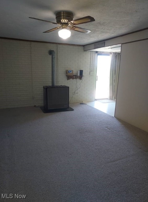 130 Maze Rd, Belpre, OH 45714 - unfurnished living room featuring a wood stove, carpet, and a ceiling fan