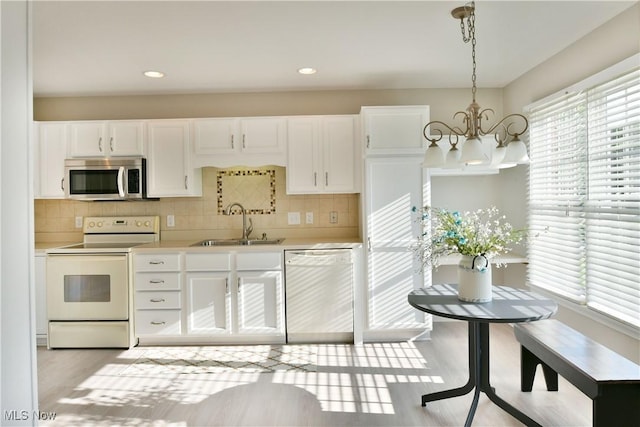 100 Turnberry Ct NE, Warren, OH 44484 - kitchen featuring white appliances, a sink, a chandelier, light countertops, and backsplash