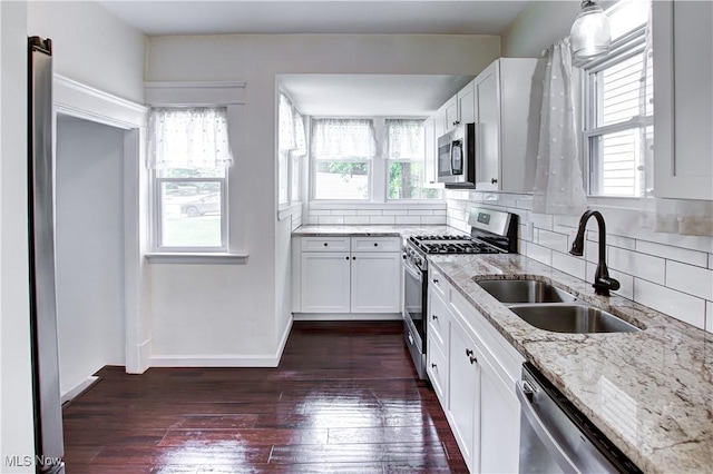 2577 Idlewood Rd, Cleveland Heights, OH 44118 - kitchen with appliances with stainless steel finishes, a sink, light stone counters, dark wood-type flooring, and backsplash