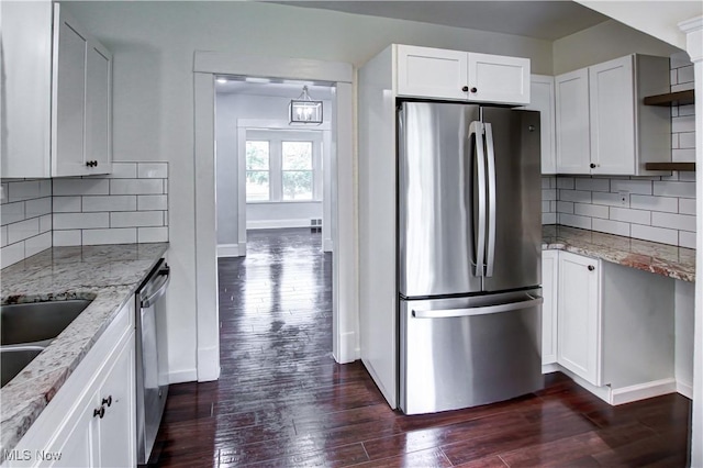 2577 Idlewood Rd, Cleveland Heights, OH 44118 - kitchen with appliances with stainless steel finishes, light stone counters, dark wood-style flooring, and white cabinetry
