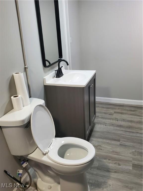 7007 Biddulph Rd, Brooklyn, OH 44144 - bathroom featuring toilet, vanity, wood finished floors, and baseboards