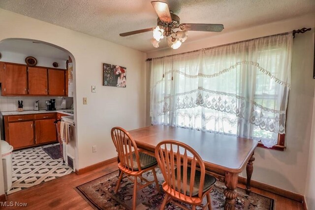 5920 Renninger Rd, New Franklin, OH 44319 - dining room with ceiling fan, arched walkways, baseboards, wood finished floors, and a textured ceiling