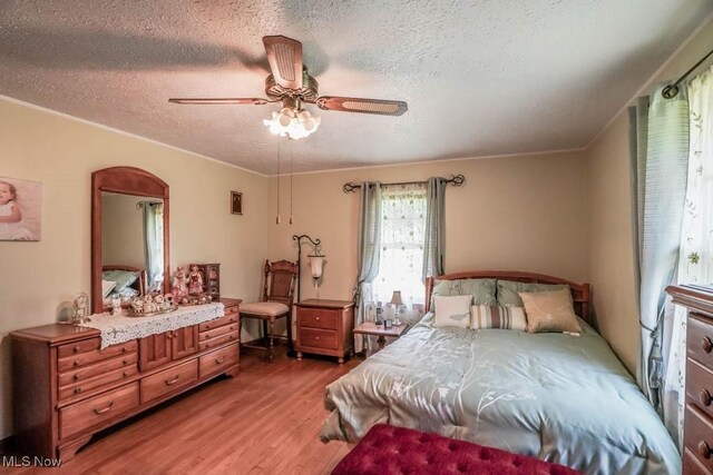 5920 Renninger Rd, New Franklin, OH 44319 - bedroom with light wood-style floors, a textured ceiling, a ceiling fan, and ornamental molding