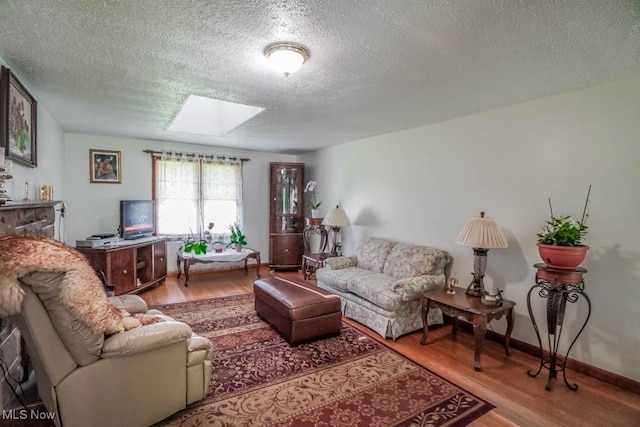5920 Renninger Rd, New Franklin, OH 44319 - living area featuring a skylight, a textured ceiling, and wood finished floors